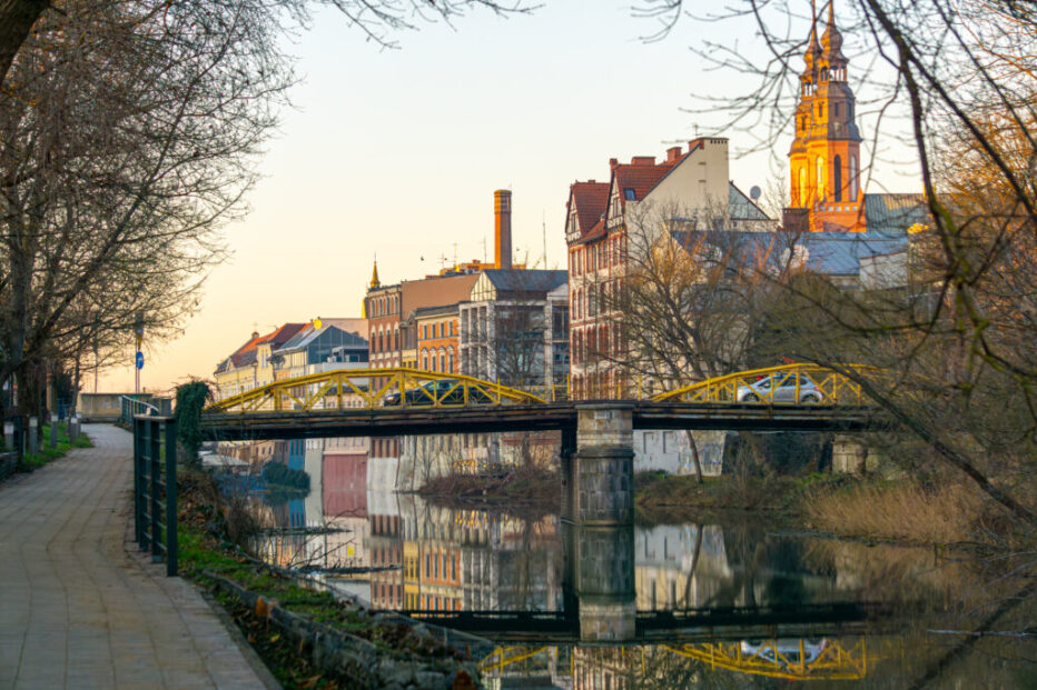 urban architecture, old buildings of residential tenement houses. tenement houses with various beautiful decorations. buildings after renovation in the city. yellow steel bridge over the river
